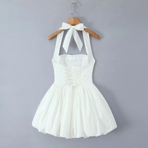 Detail of white halter neck dress with oversized bow and adjustable lace-up back