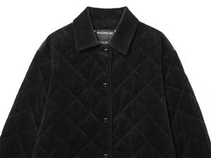 Detail of black corduroy quilted jacket featuring diamond patterns and metal buttons