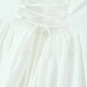 Detailed back view of white halter dress featuring corset lacing and smocked waist design