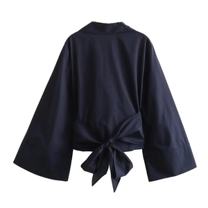 Detail view of the navy blue poplin shirt featuring a large decorative back bow tie