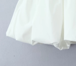 Detailed close-up of the white bubble hem with elegant pleated texture and volume
