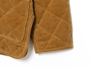 Detail shot of caramel corduroy jacket showing quilted diamond texture and fine stitching
