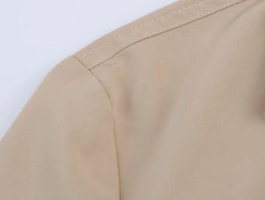 Detailed view of khaki blazer shoulder seam with durable reinforced double-stitching