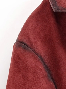 Detail of burgundy suede jacket showing distressed seams and fuzzy fabric texture