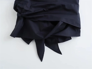 Detail view of the poplin shirt showing the unique knotted hem and draped fabric design