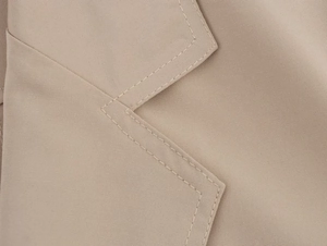 Detailed close-up of khaki blazer lapel featuring neat double-row stitching and twill fabric
