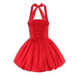 Detail of red halter dress featuring an open back with crisscross lacing and bubble hem