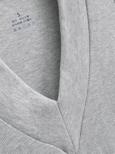 Detail of grey V-neck tee showing ribbed cotton texture and printed care label