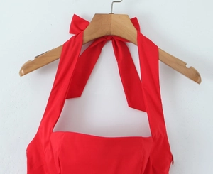 Detail of red halter dress top featuring an elegant oversized bow and cotton texture