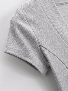 Detailed macro view of the grey ribbed fabric and stitching on a deep V-neck T-shirt