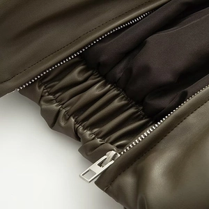 Detail of dark olive PU leather jacket with silver metal zipper and elastic hem