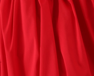 Detailed macro view of vibrant red chiffon fabric with soft drapes and fine texture