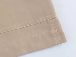Close-up of double-stitched seams on khaki blazer fabric showing high-quality craftsmanship