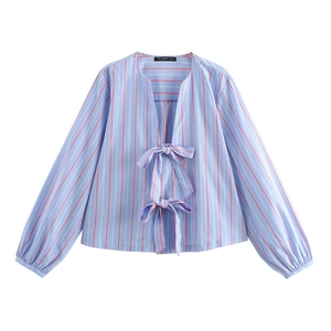 Detail of light blue striped shirt featuring red pinstripes and bow-tie front closures