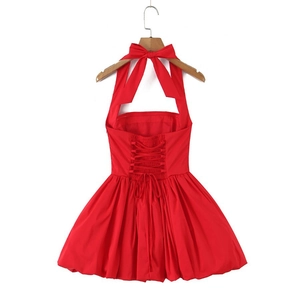 Detail of red halter neck dress featuring large bow and corset lace-up back design