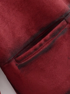 Detail of burgundy faux suede jacket showing black distressed spray effect on the pocket edge