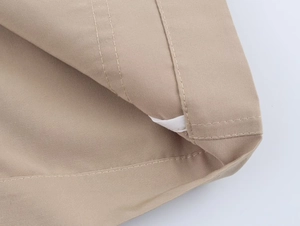 Detailed close-up of khaki blazer fabric with double-stitched seams and smooth texture