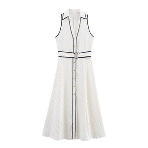 Detail view of white sleeveless polka dot dress with lapel collar and waist belt