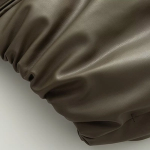 Detailed macro view of high-quality pleated PU leather texture with rich dark brown finish