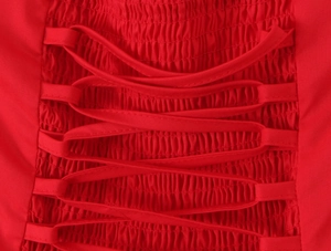 Close-up of red smocked fabric with elastic texture and decorative criss-cross lacing detail