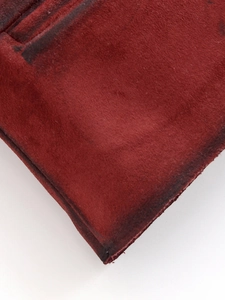 Macro shot of dark red suede texture and clean cut edge of the jacket fabric