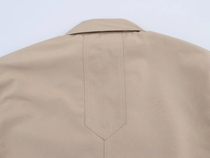 Detailed close-up of khaki blazer back seam with precise stitching and fabric texture