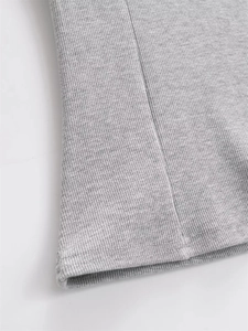 Close-up of grey ribbed fabric showing detailed vertical texture and stitched hemline