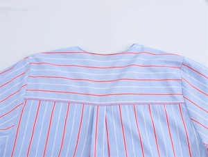 Detail of striped shirt featuring red stripe patchwork and purple zigzag stitching