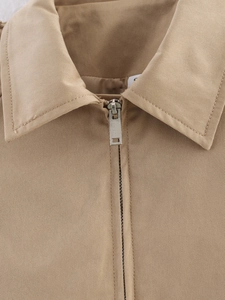 Close-up of khaki jacket lapel collar with silver metal zipper and twill fabric texture