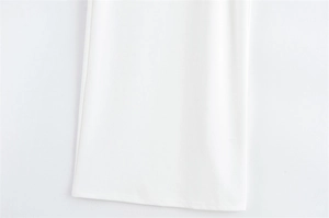 Gros plan sur l'ourlet d'une robe blanche montrant le tissage sergé et les coutures