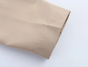 Macro view of khaki twill fabric showing detailed stitching and smooth material texture