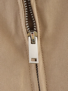 Detailed macro shot of silver metal zipper and premium khaki twill fabric stitching