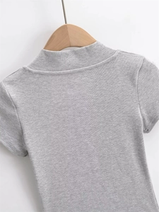 Close-up detail of grey ribbed knit fabric texture on short sleeve V-neck crop top