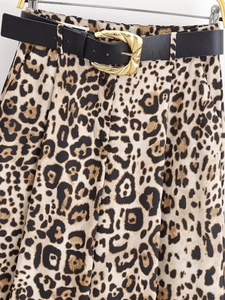 Détail d'un pantalon large à imprimé léopard avec ceinture noire et boucle dorée