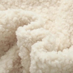 Close-up of the plush cream fleece fabric texture for bow-tie sleeveless vest jacket