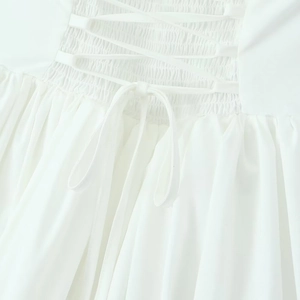 White halter dress with backless shirring and criss-cross tie detailing for summer