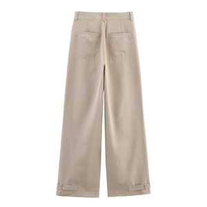Detail of khaki wide-leg trousers featuring rear pockets and adjustable button hem straps