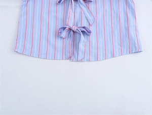 Close-up of blue and white striped shirt fabric with red lines and a bow tie detail