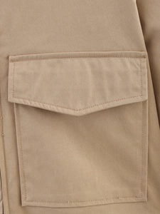 Detail view of khaki twill jacket showing the flap pocket and fine stitching craftsmanship