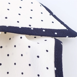 Macro detail of polka dot dress showing high-quality stitching and woven texture