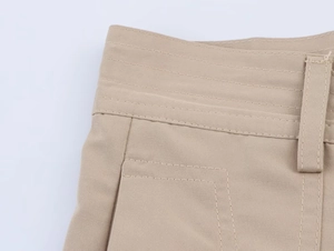 Detail of khaki high waist trousers showing parallel stitching and twill fabric texture