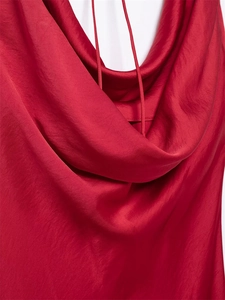 Dettaglio dell'elegante scollo a cappuccio su abito in raso rosso scuro con spalline