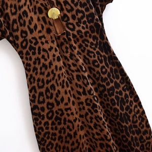 Detailed view of the gold shell zipper pull on the leopard print velvet dress fabric