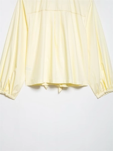 Detail of soft cream yellow striped shirt showing back decorative stitching and lantern sleeves