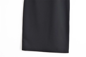 Vue détaillée des coutures nettes et de la texture sergée du tissu noir de la robe ajustée