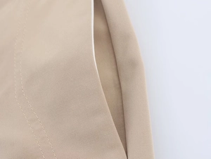 Detailed macro shot of the khaki trousers side pocket with white hem and double stitching