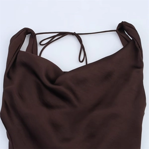 Dettaglio dell'elegante scollo a cappuccio e della trama satinata di un abito caffè scuro