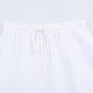 Dettaglio gonna bianca in cotone e lino con coulisse elastica in vita e volant