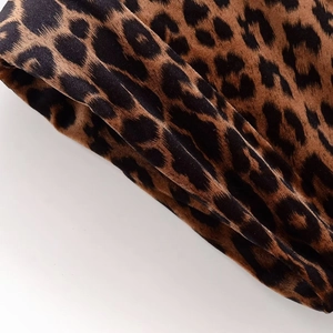 Close-up of velvet leopard print fabric showing soft texture and luxury brown patterns