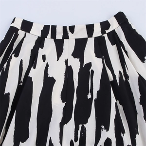 Détail d'une jupe taille haute présentant des motifs de rayures artistiques noirs et blancs